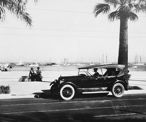 Historical photo of a car in front of the beach in Santa Barbara.