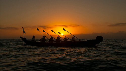 Rowing a Tomol canoe at sunset.